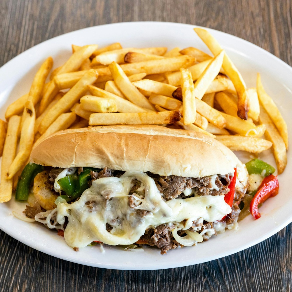 A steak and cheese hoagie with fries